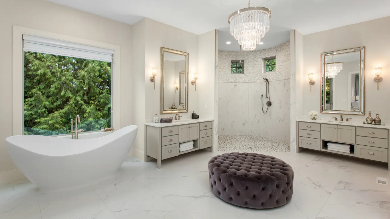 Bathroom remodeling project in Los Angeles with freestanding tub, large walk-in shower, double vanities, chandelier lighting, marble-style tile, and spa-inspired primary bathroom design