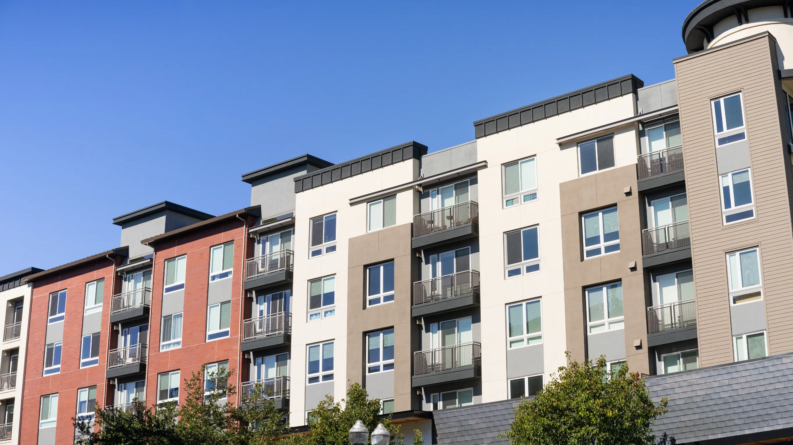 After photo of condo remodeling project in Los Angeles with modern multi-unit building exterior, balconies, updated facade, residential windows, and improved urban condo property appearance