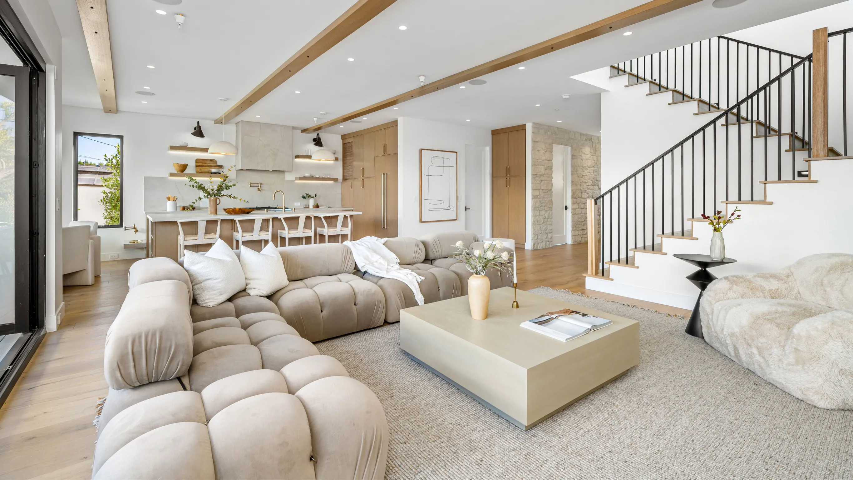 After home remodeling project in Los Angeles with open-concept living room, updated kitchen flow, modern staircase, wood flooring, recessed lighting, and bright interior layout