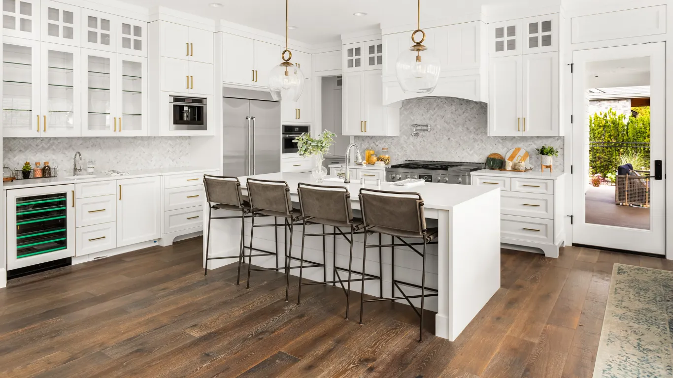 Kitchen remodeling project in Los Angeles with white cabinets, large island, pendant lighting, marble-style backsplash, stainless steel appliances, and premium open kitchen design