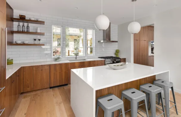 Kitchen remodeling in Los Angeles with custom wood cabinetry, white tile backsplash, large kitchen island, open shelving, and modern pendant lights